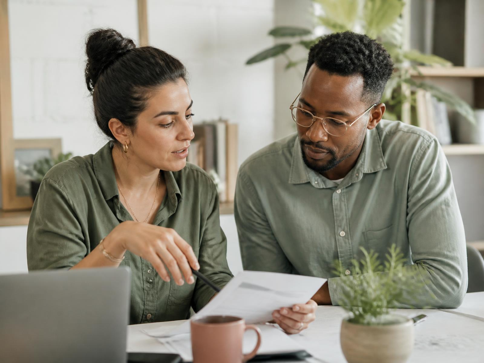 Two members of a care operations team reviewing a document together